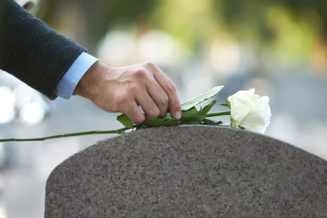 Placing a rose on a grave during a funeral