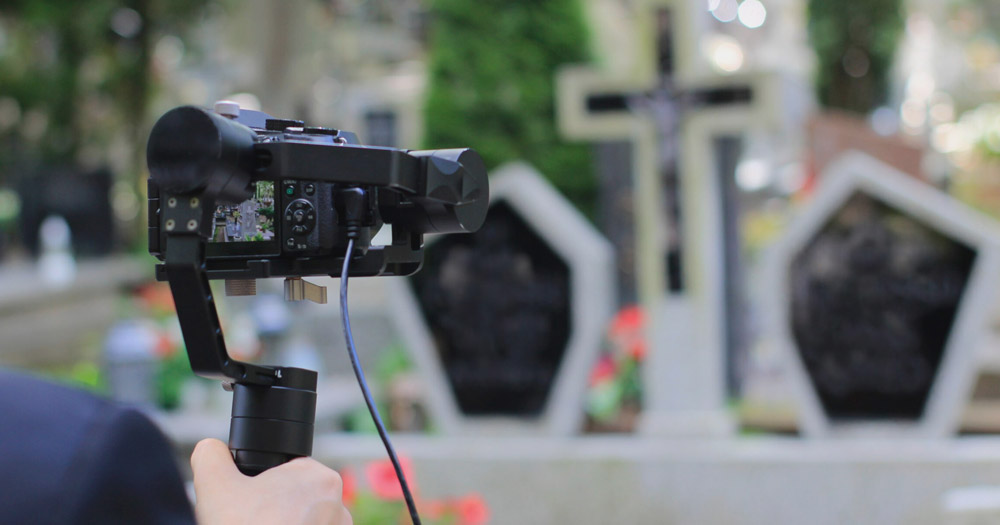funeral videographer working at a cemetery